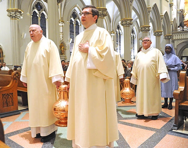 Priests carry vessels of olive oil to the altar before they are blessing by the Bishop at St. Joseph Cathedral during the annual Chrism Mass. (Dan Cappellazzo/Staff Photographer)